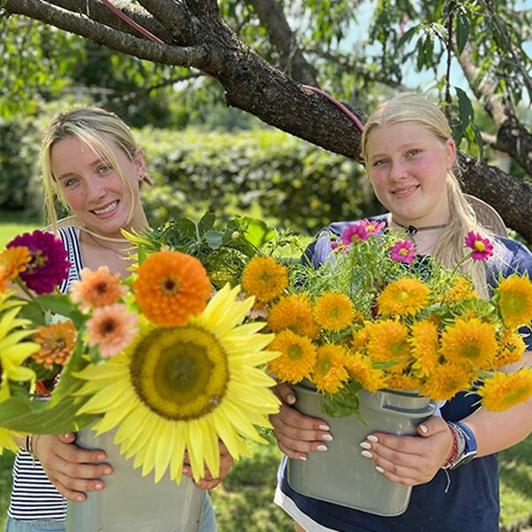 Elle and Scarlett holding large bright bouquets