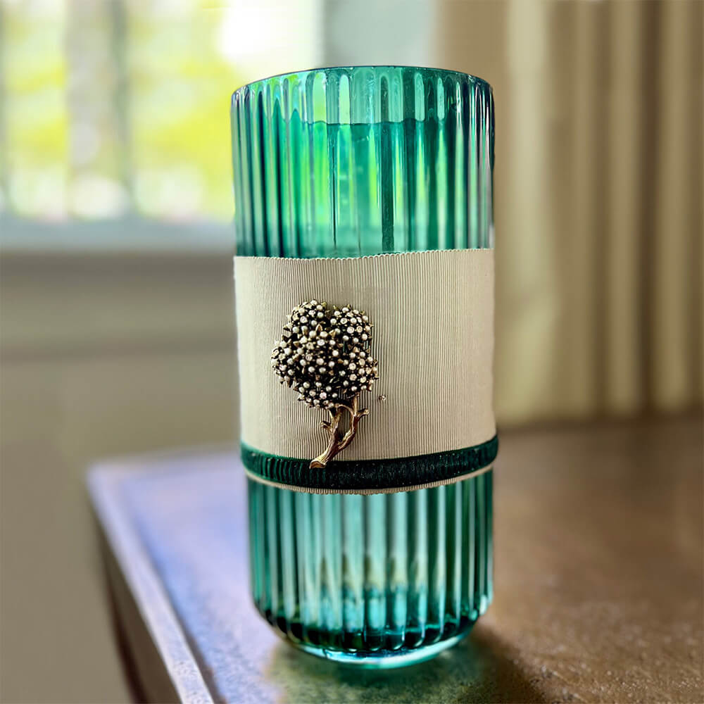 green vase with ribbon and gold floral accent